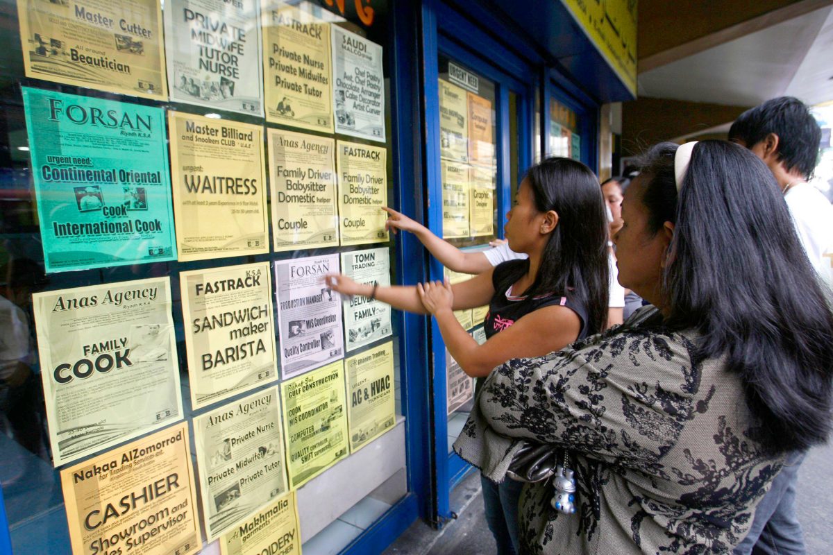 Applicants look at job offers displayed on a glass window of a recruitment agency in Manila in this October 9, 2010 file photo. An average of more than 3,000 workers leave the country daily to work as professionals, nurses, doctors, domestic helpers, seaf