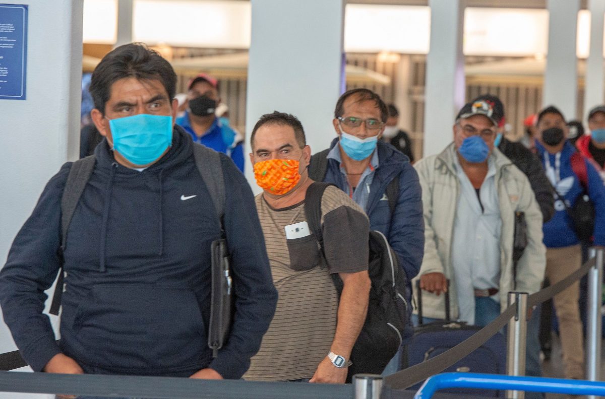 Migrant workers from Mexico maintain social distancing as they wait to be transported to Quebec farms after arriving at Trudeau Airport Tuesday April 14, 2020 in Montreal.